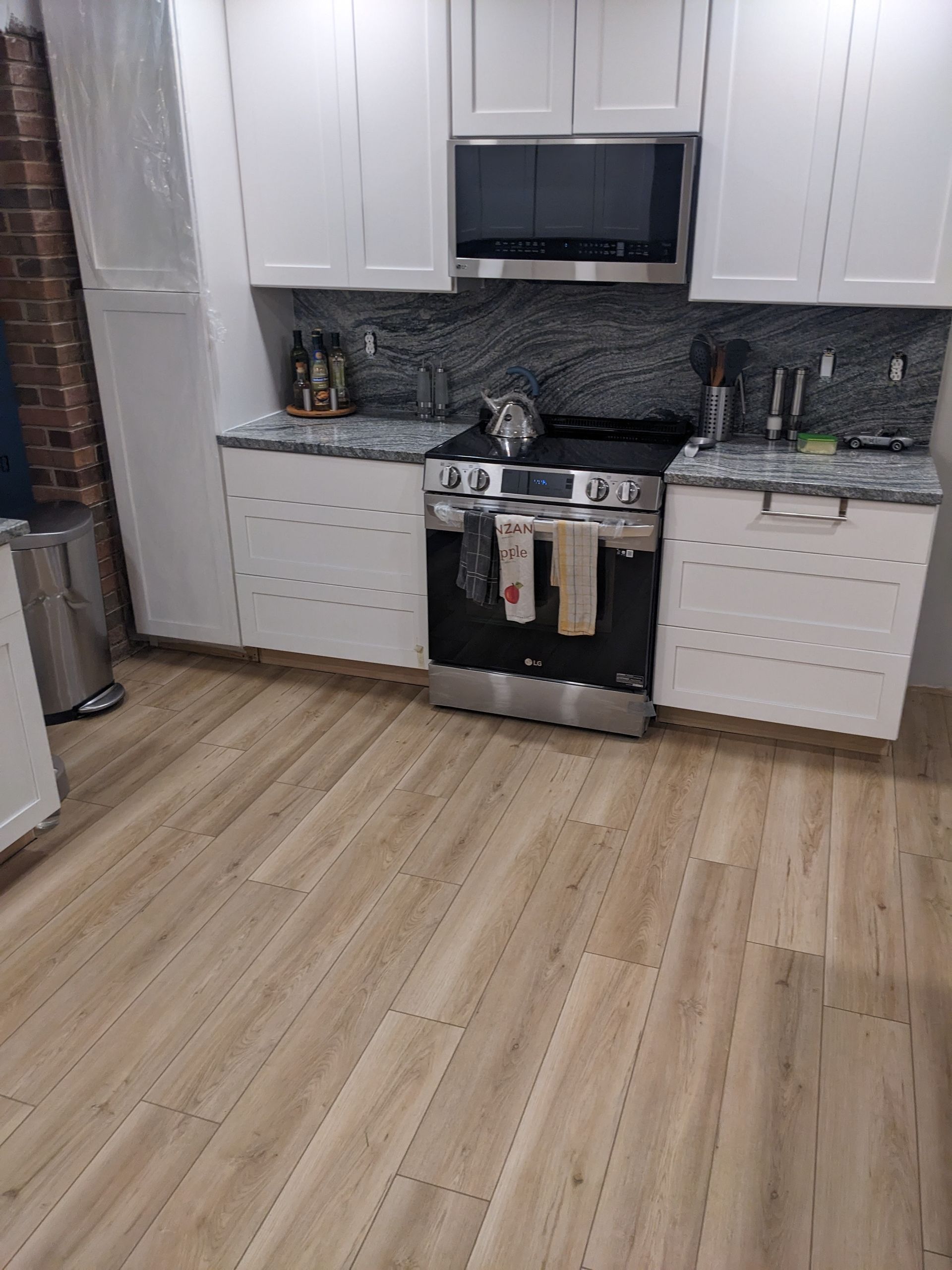 A kitchen with a stove , sink , and microwave.