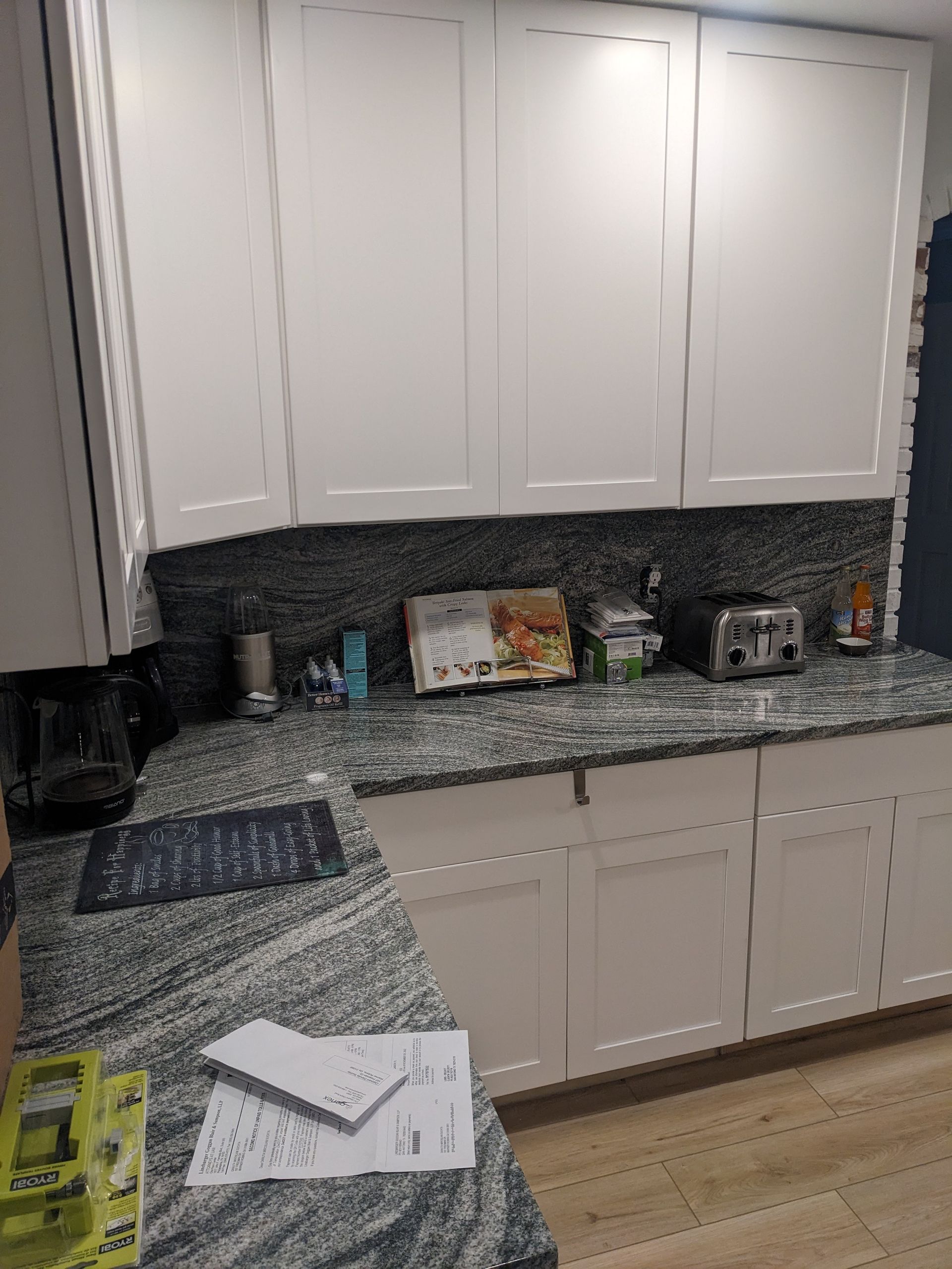 A kitchen with granite counter tops and white cabinets.
