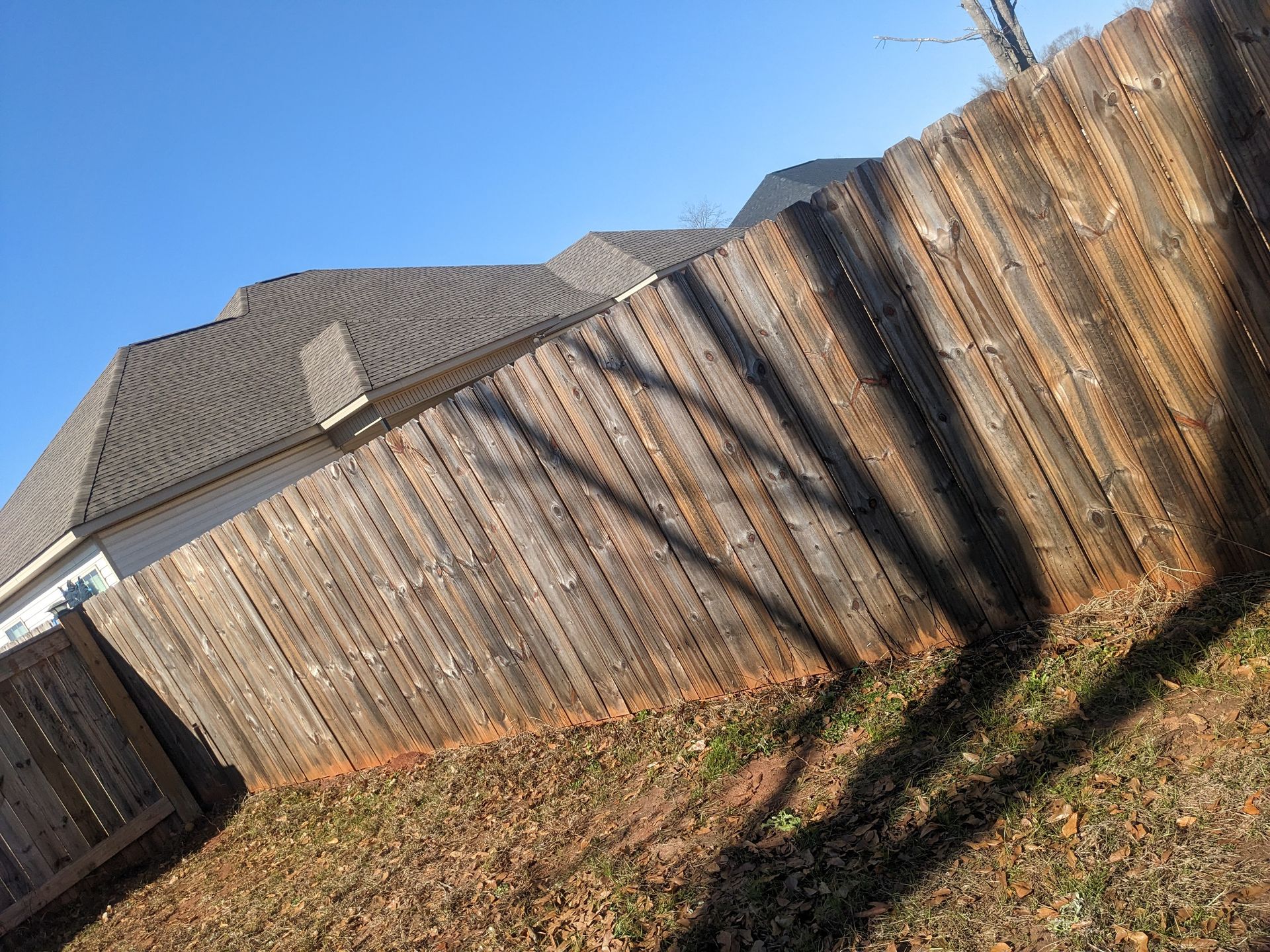 A wooden fence with a house in the background