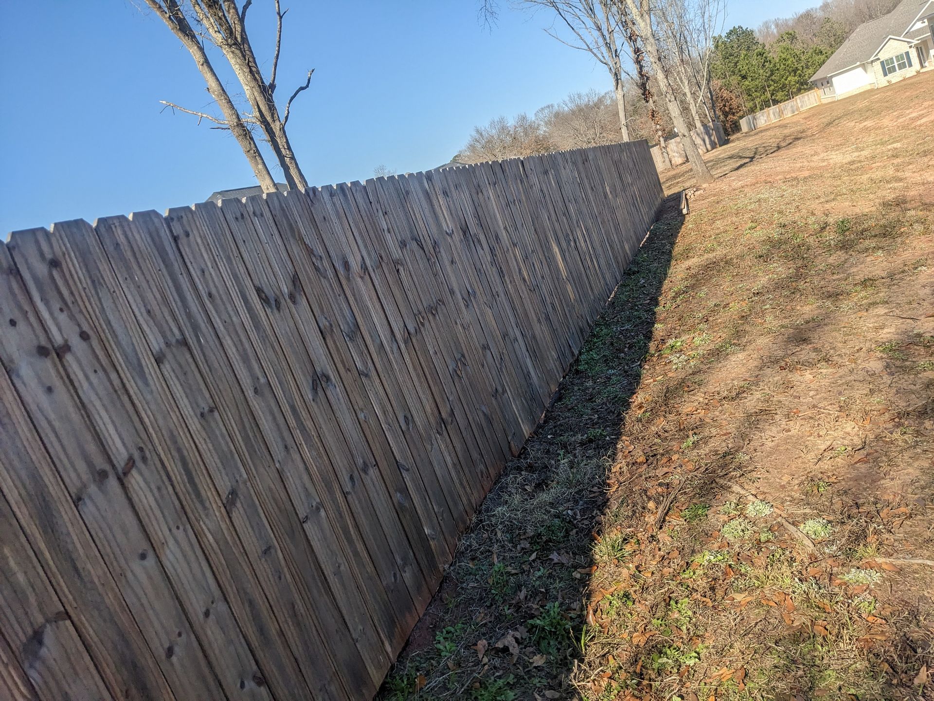 A wooden fence is sitting on top of a grassy hill.