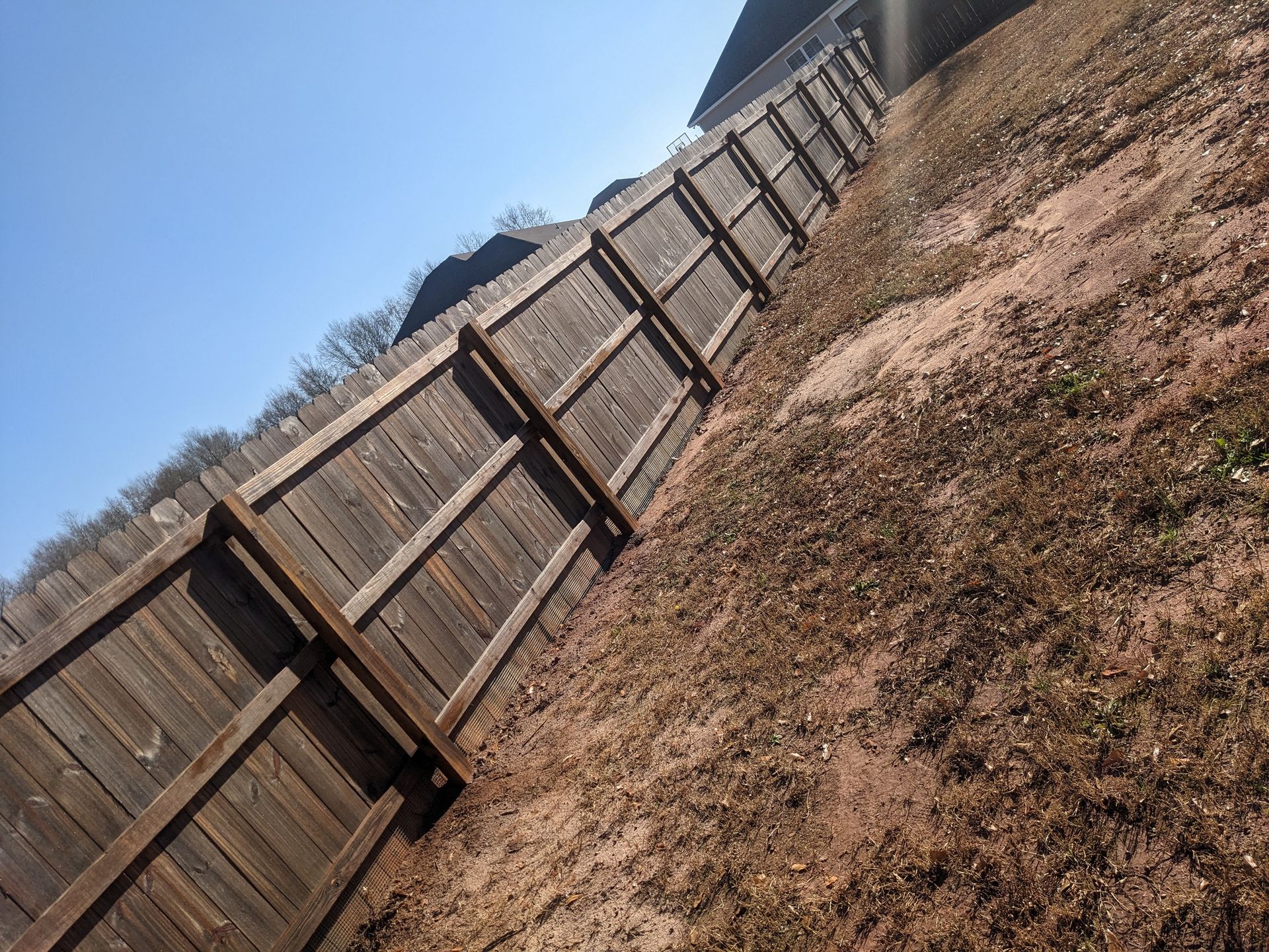 A wooden fence is sitting on top of a dirt hill.