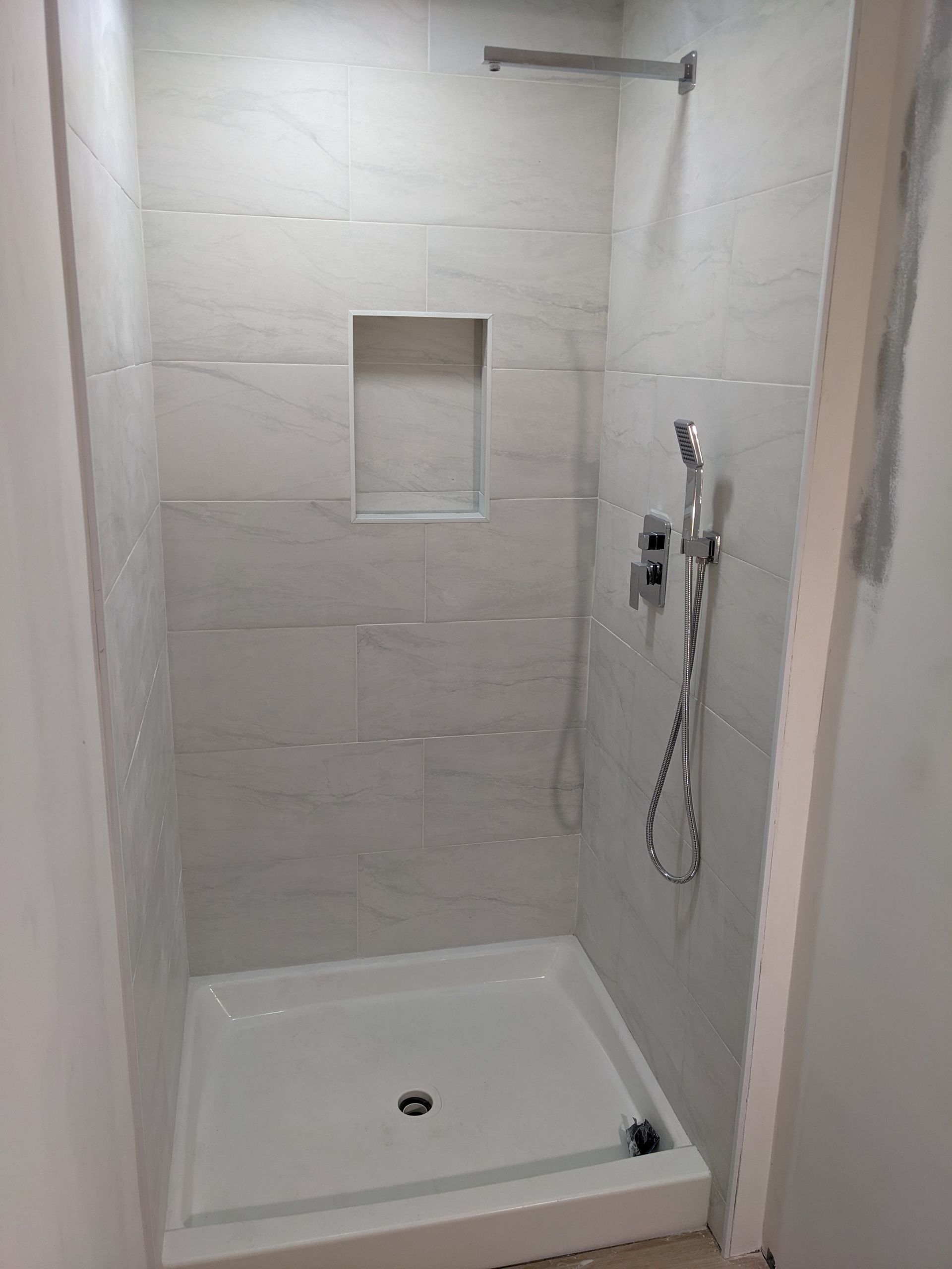 A shower stall with a shower head in a bathroom.