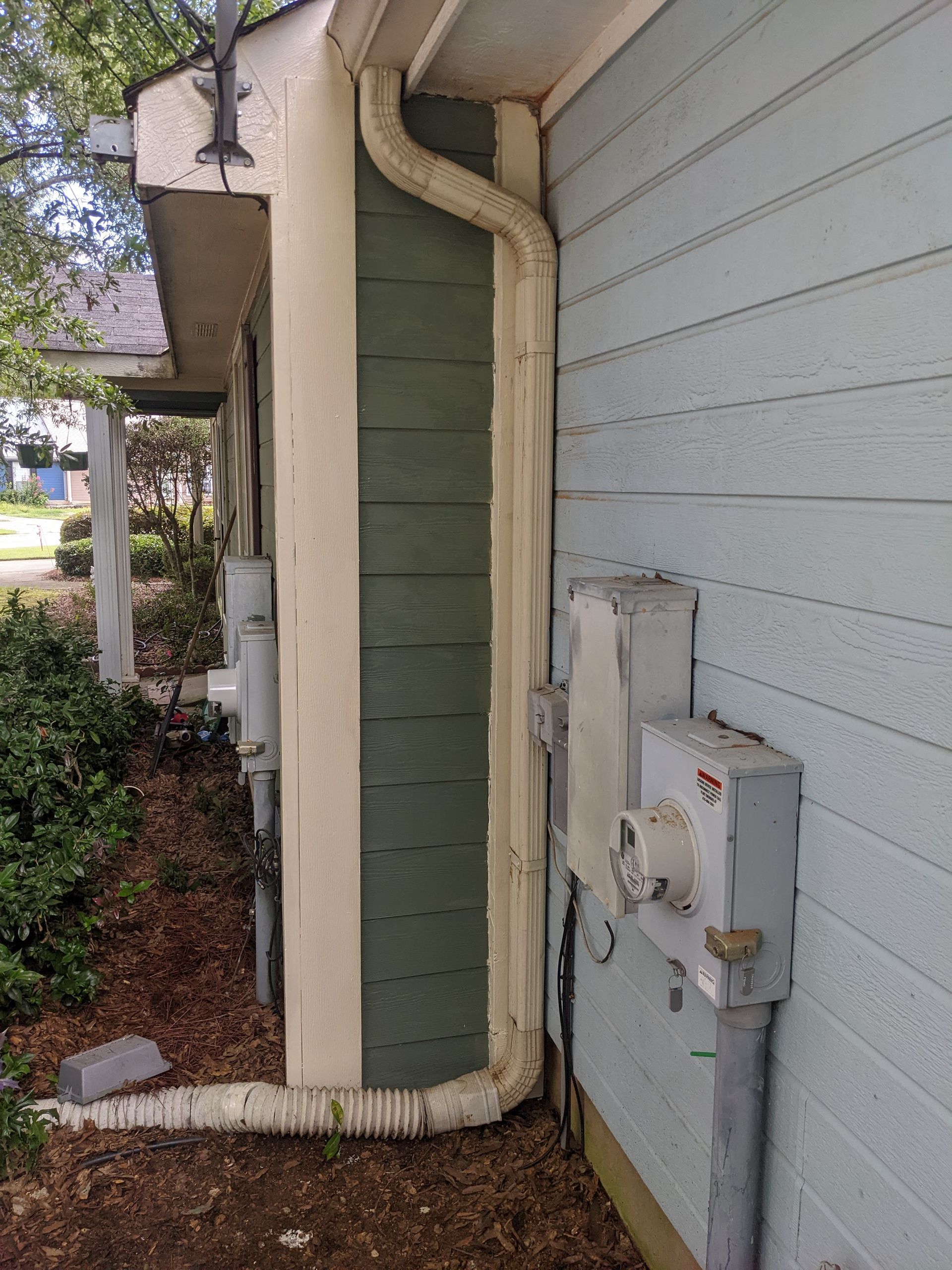 A house with a drain pipe on the side of it.