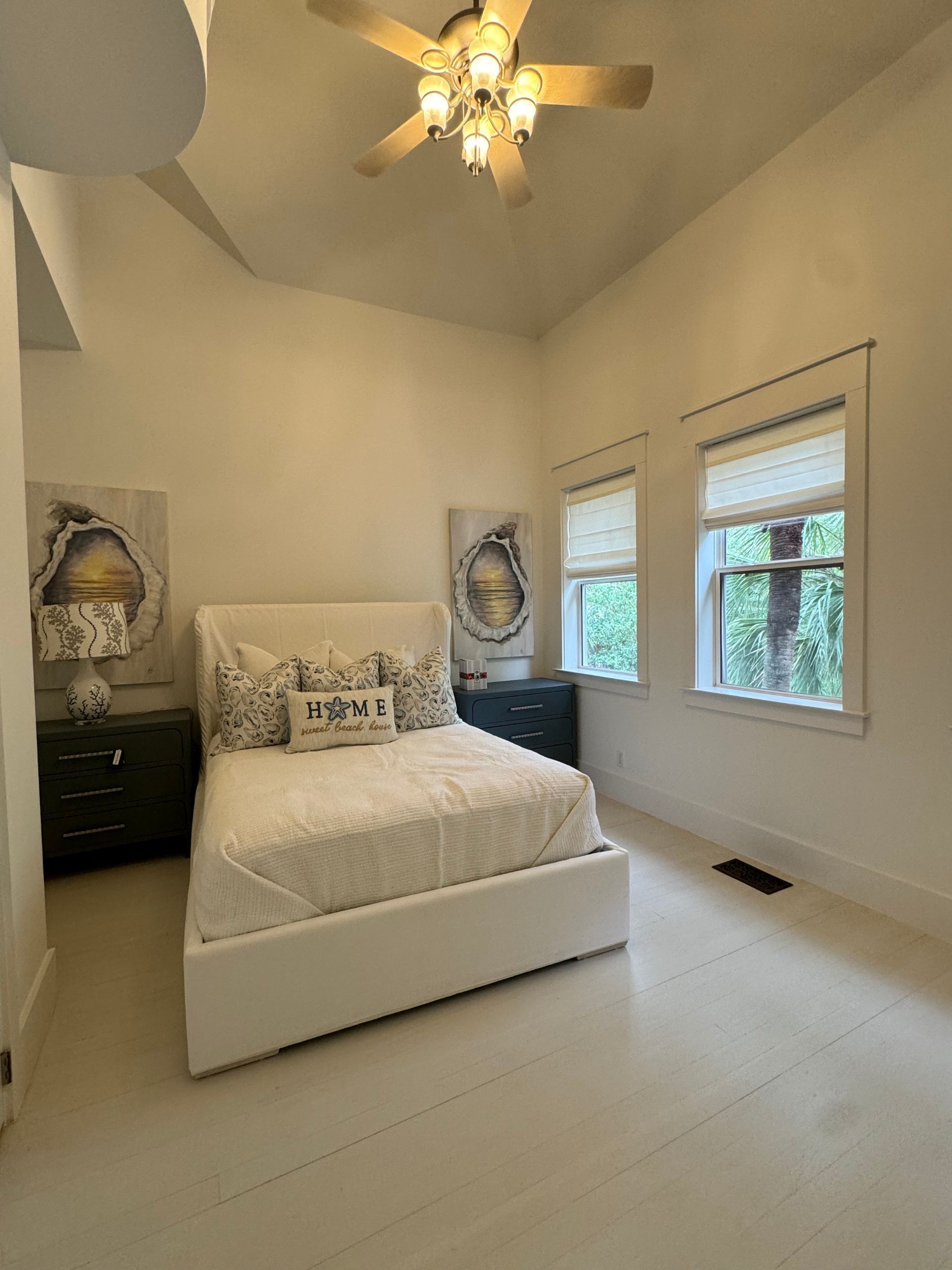 A bedroom with a bed , nightstand , and ceiling fan.