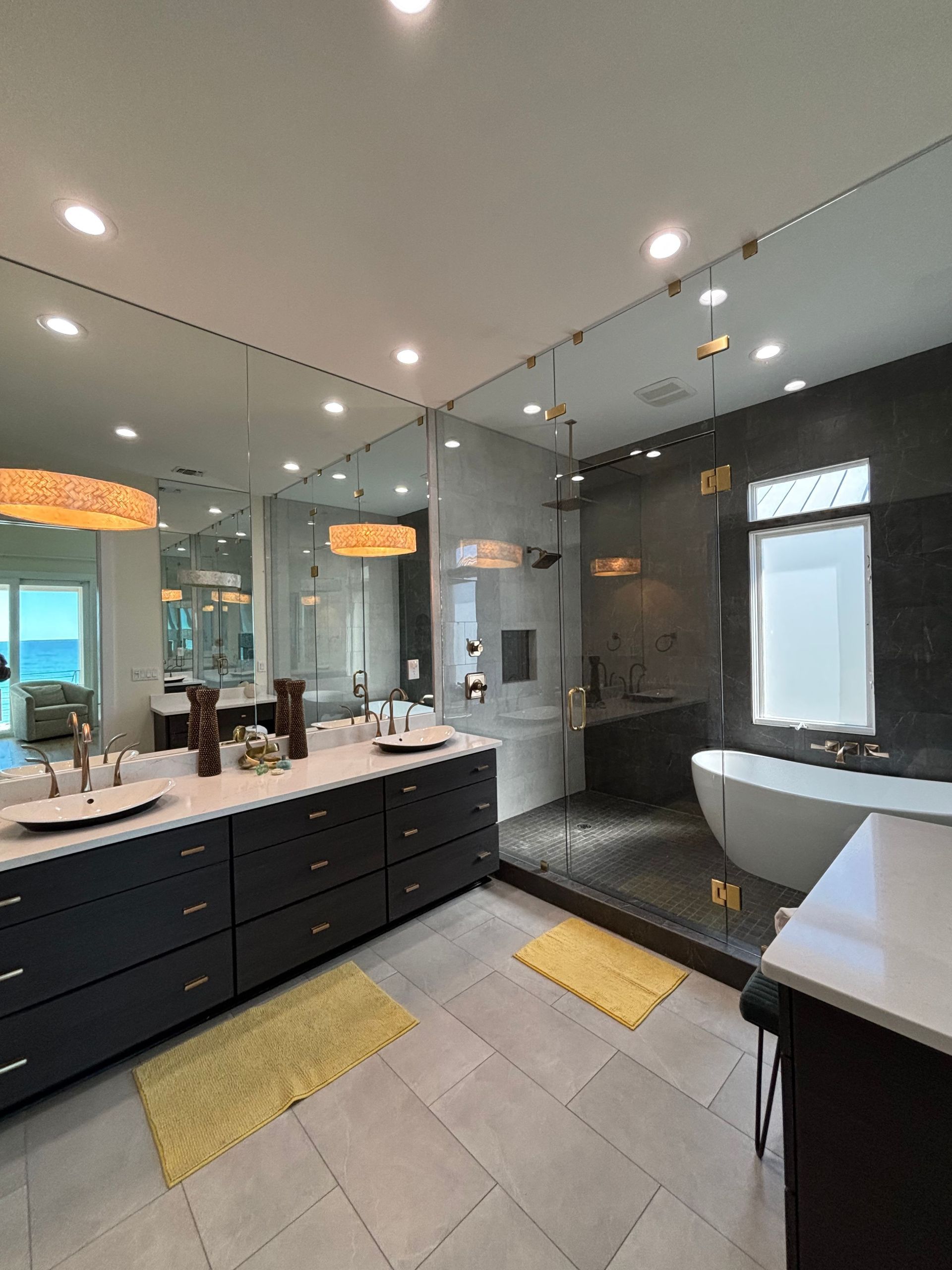 A bathroom with two sinks , a tub , and a large mirror.