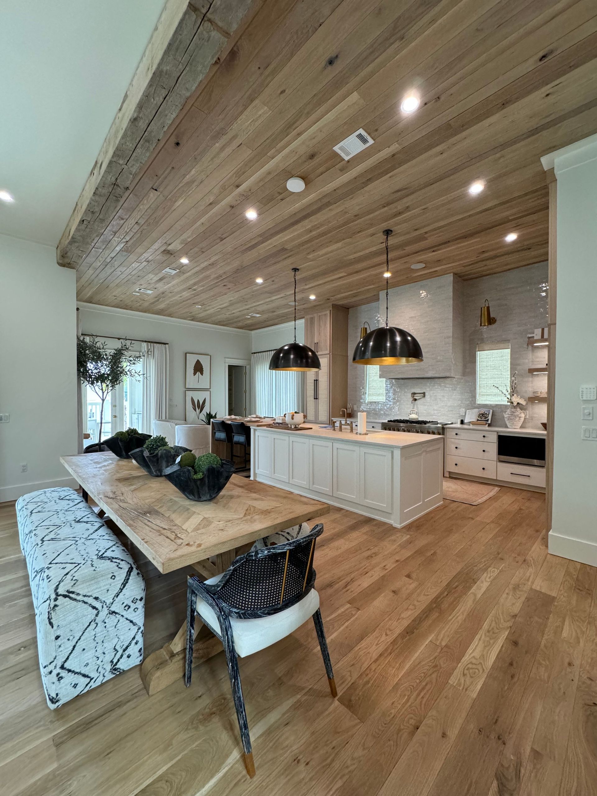 A kitchen with a wooden table and chairs and a wooden ceiling.