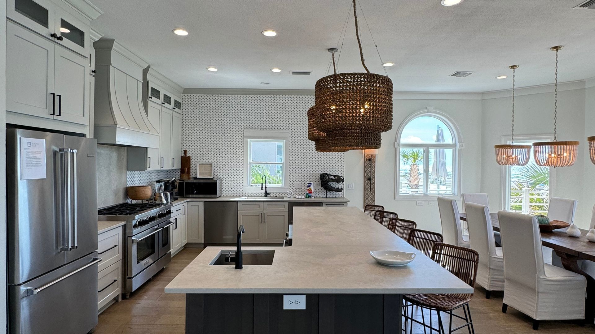 A kitchen with stainless steel appliances and a large island in the middle.