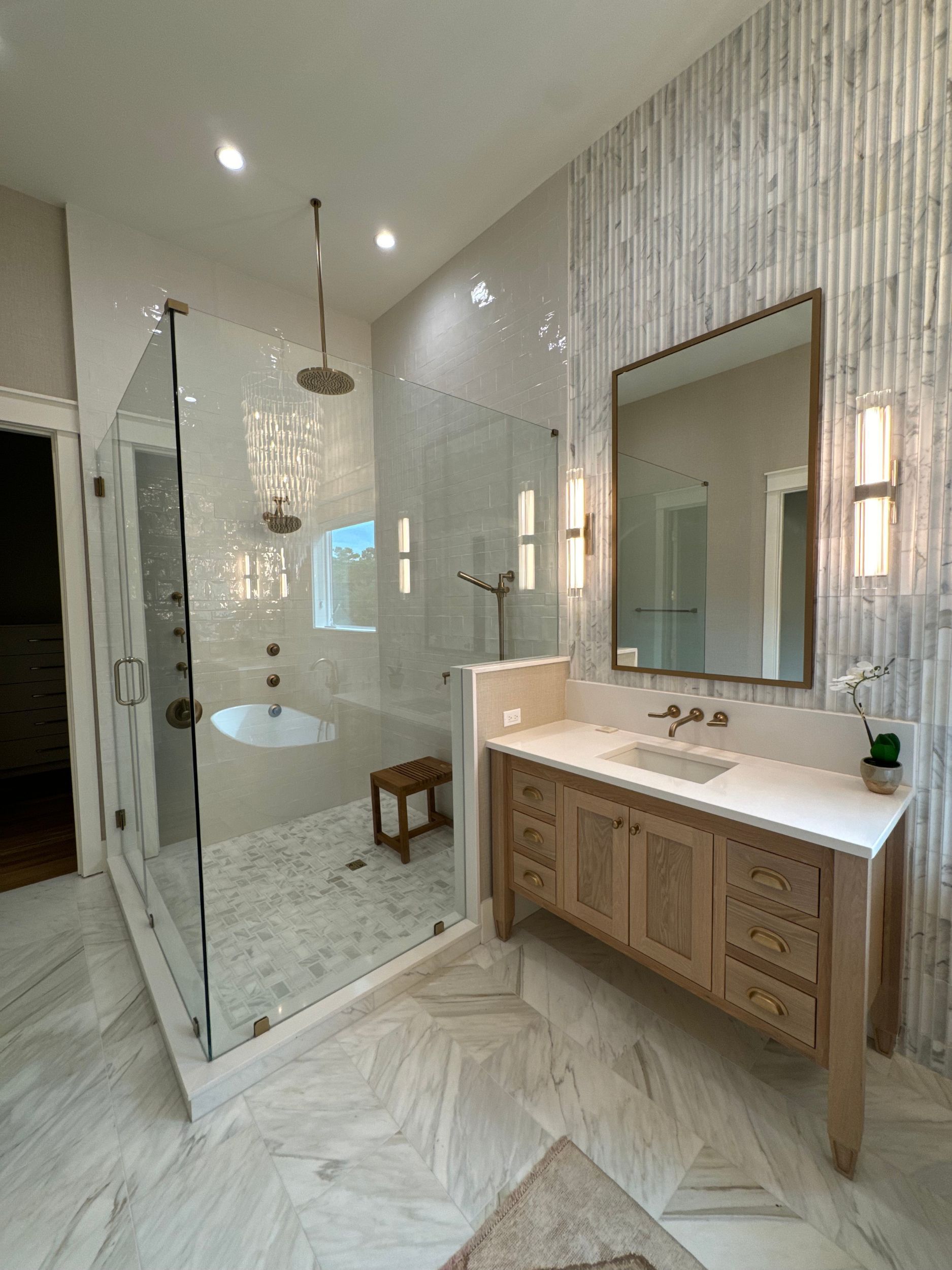 A bathroom with a walk in shower , sink , and mirror.