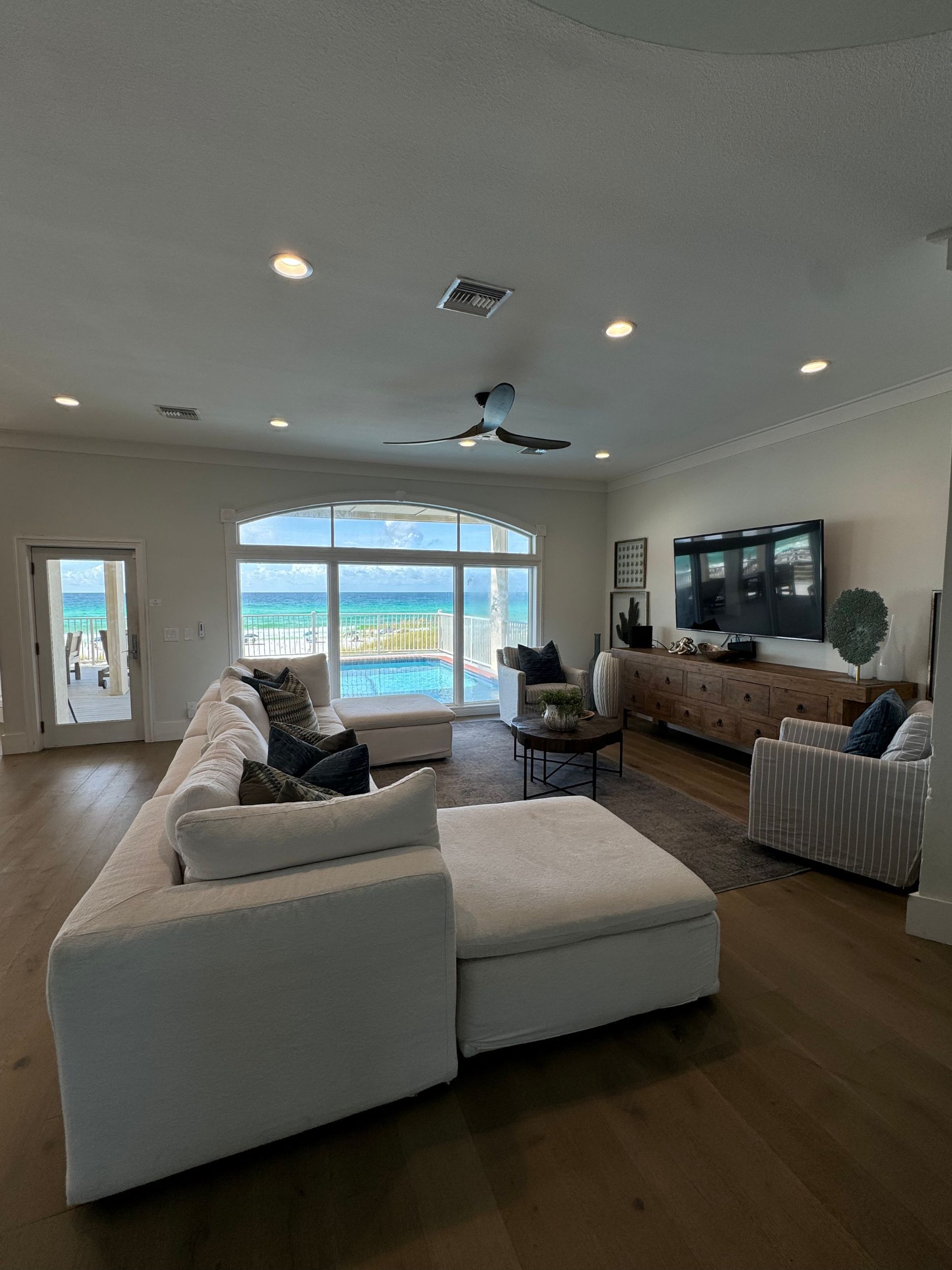A living room with a couch , chairs , and a television.