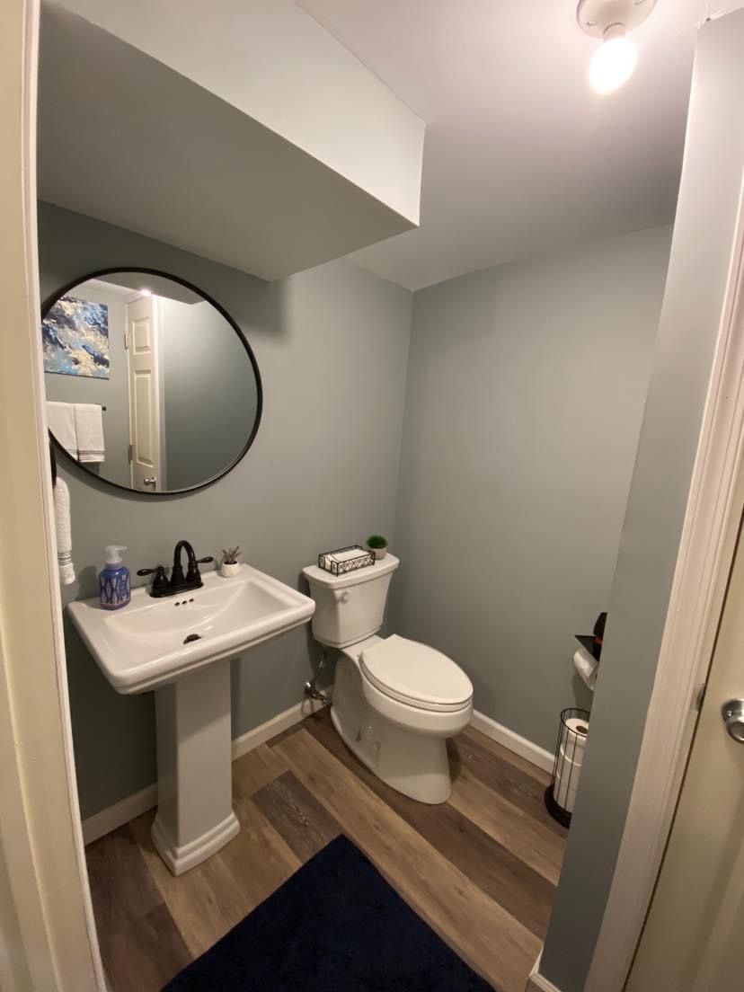 A bathroom with a toilet , sink and mirror