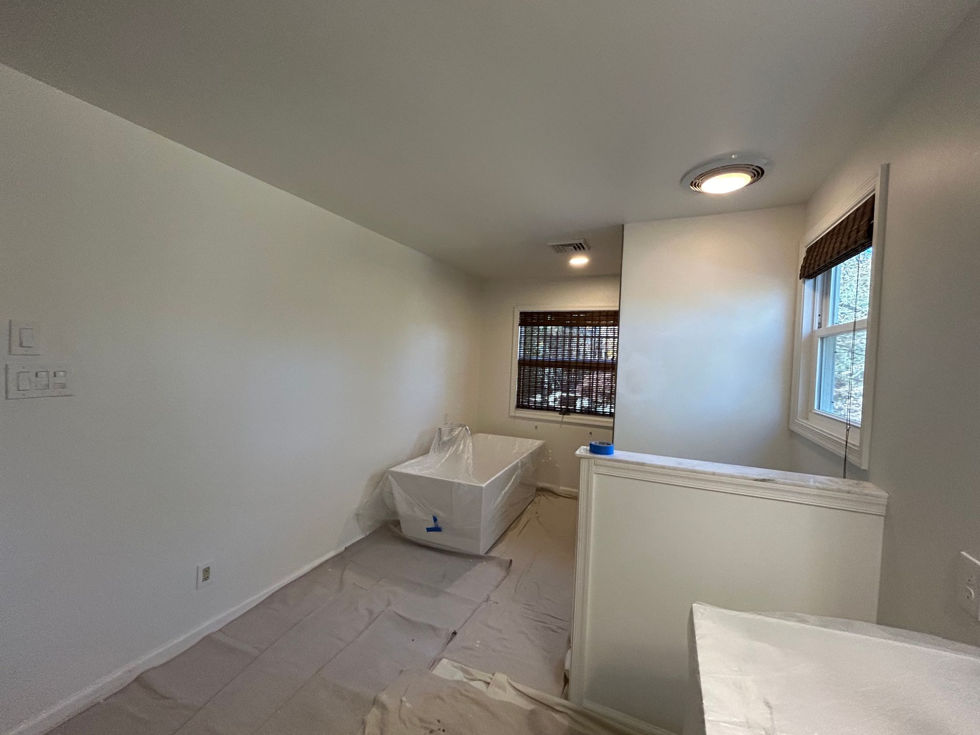 A bathroom with a bathtub and a window.