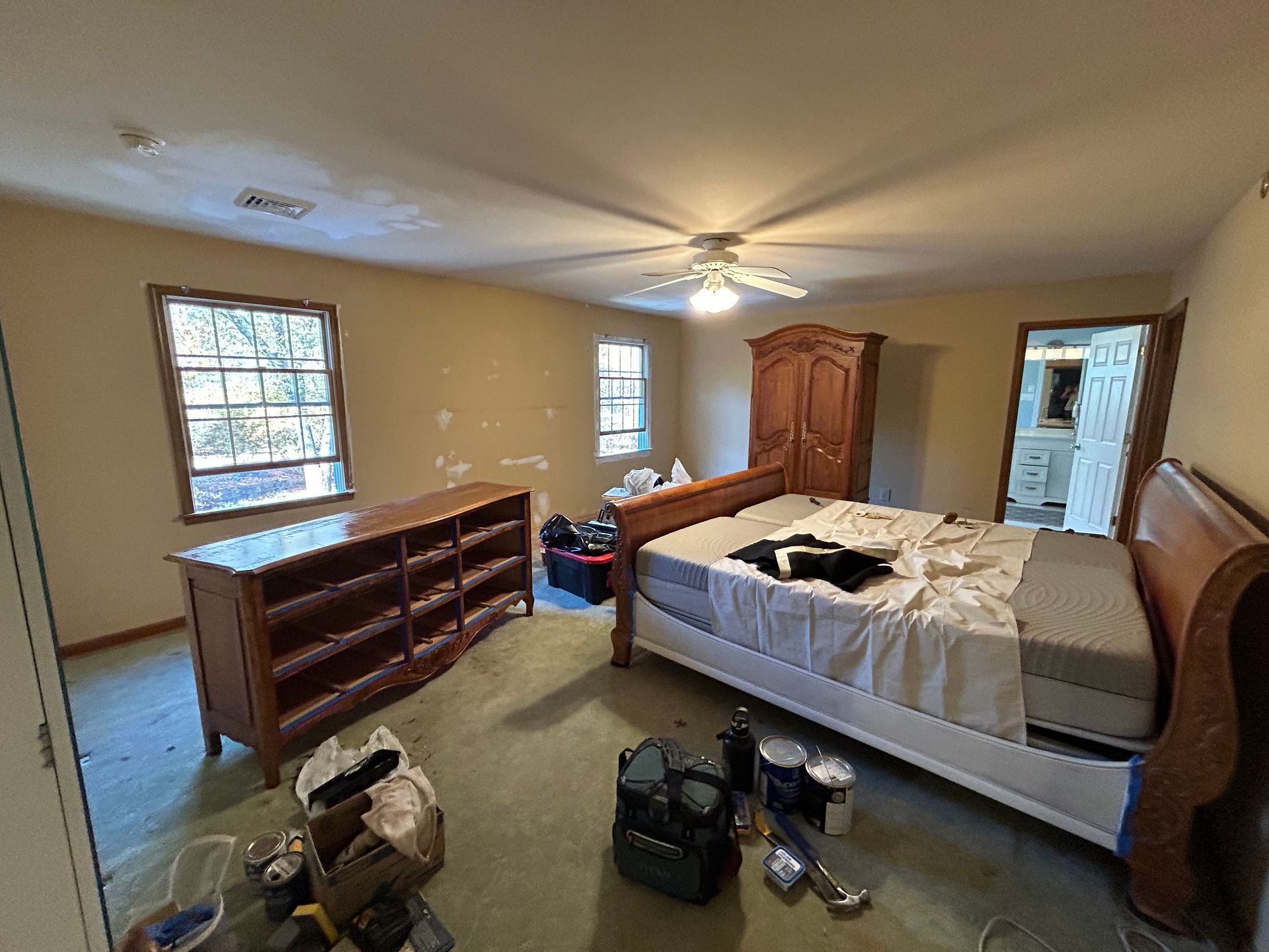 A bedroom with a bed , dresser , and ceiling fan.