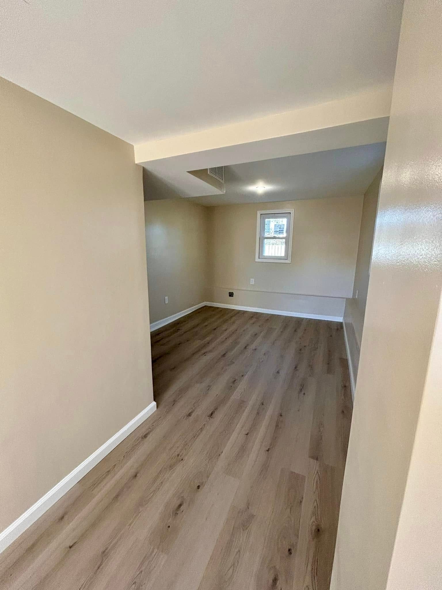 A living room with hardwood floors and a window.