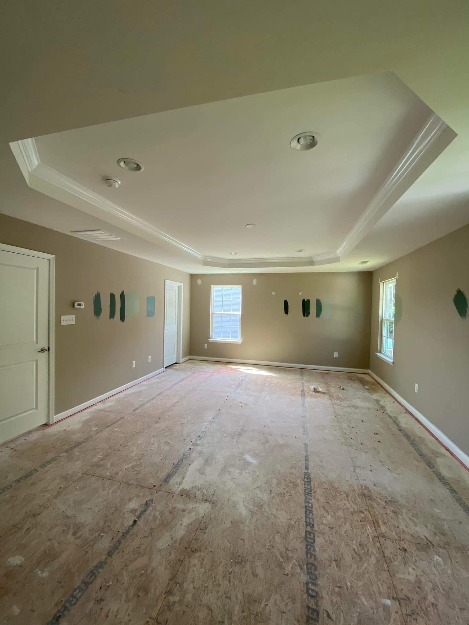 A large empty room with a wooden floor and a ceiling.