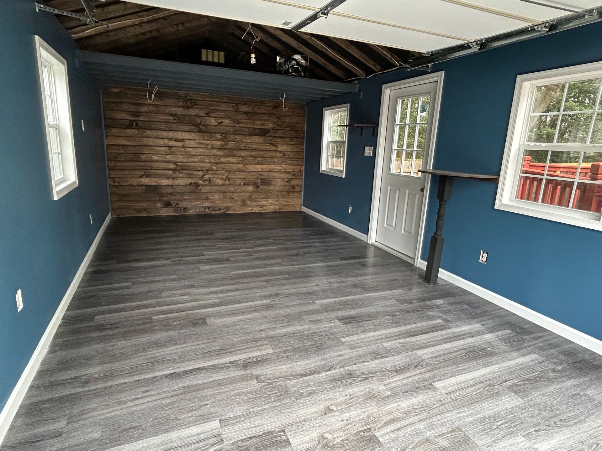 An empty room with blue walls and a wooden floor.