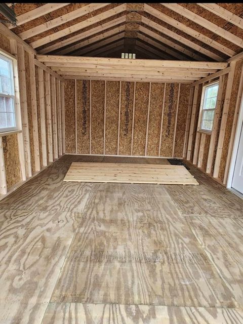 The inside of a wooden garage with a wooden floor.