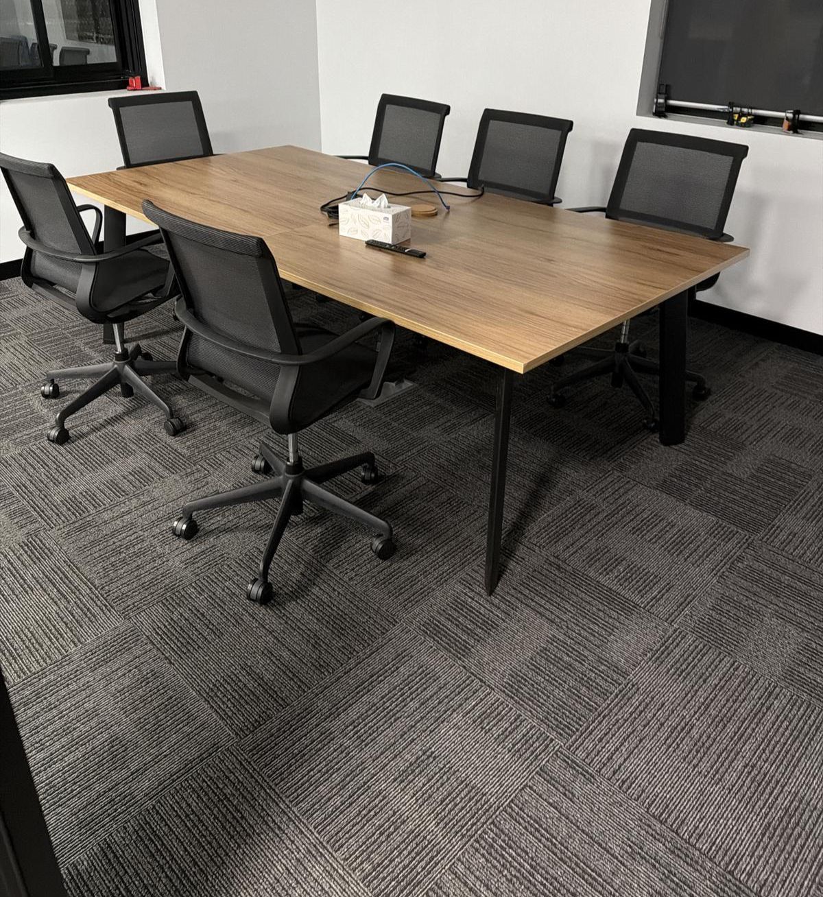 Uniformed cleaner in bright modern open-plan corporate office