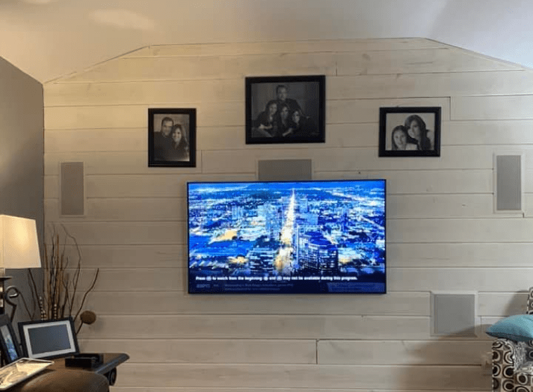 A living room with a flat screen tv hanging on the wall.