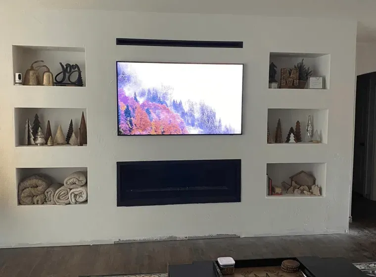 A living room with a flat screen tv mounted on the wall.