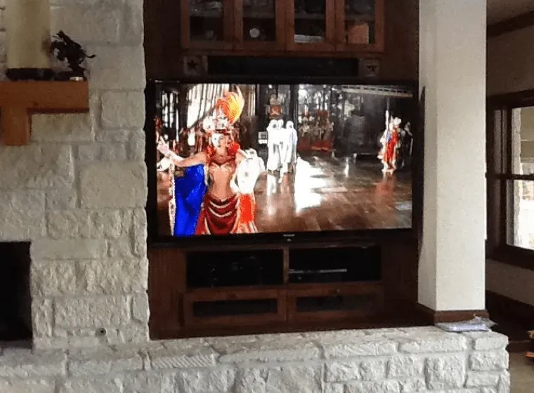 A flat screen tv is mounted to a brick wall