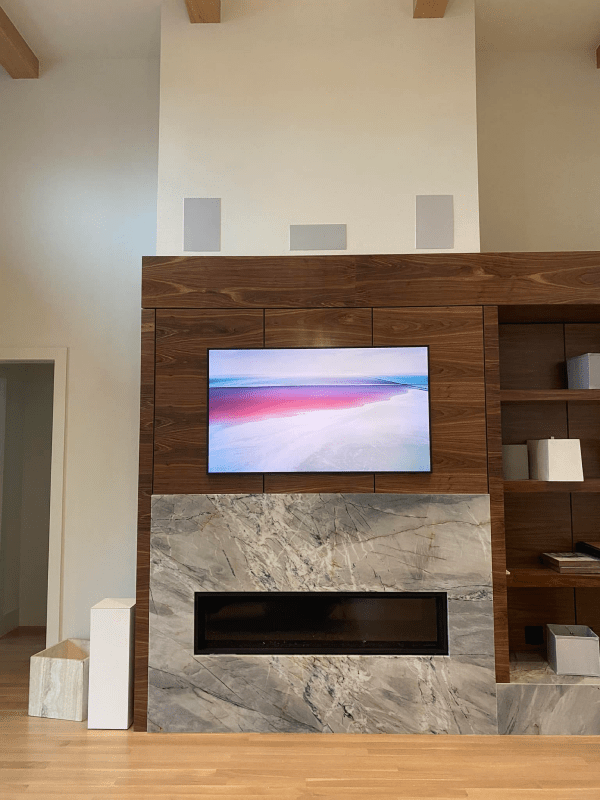 A flat screen tv is mounted above a fireplace