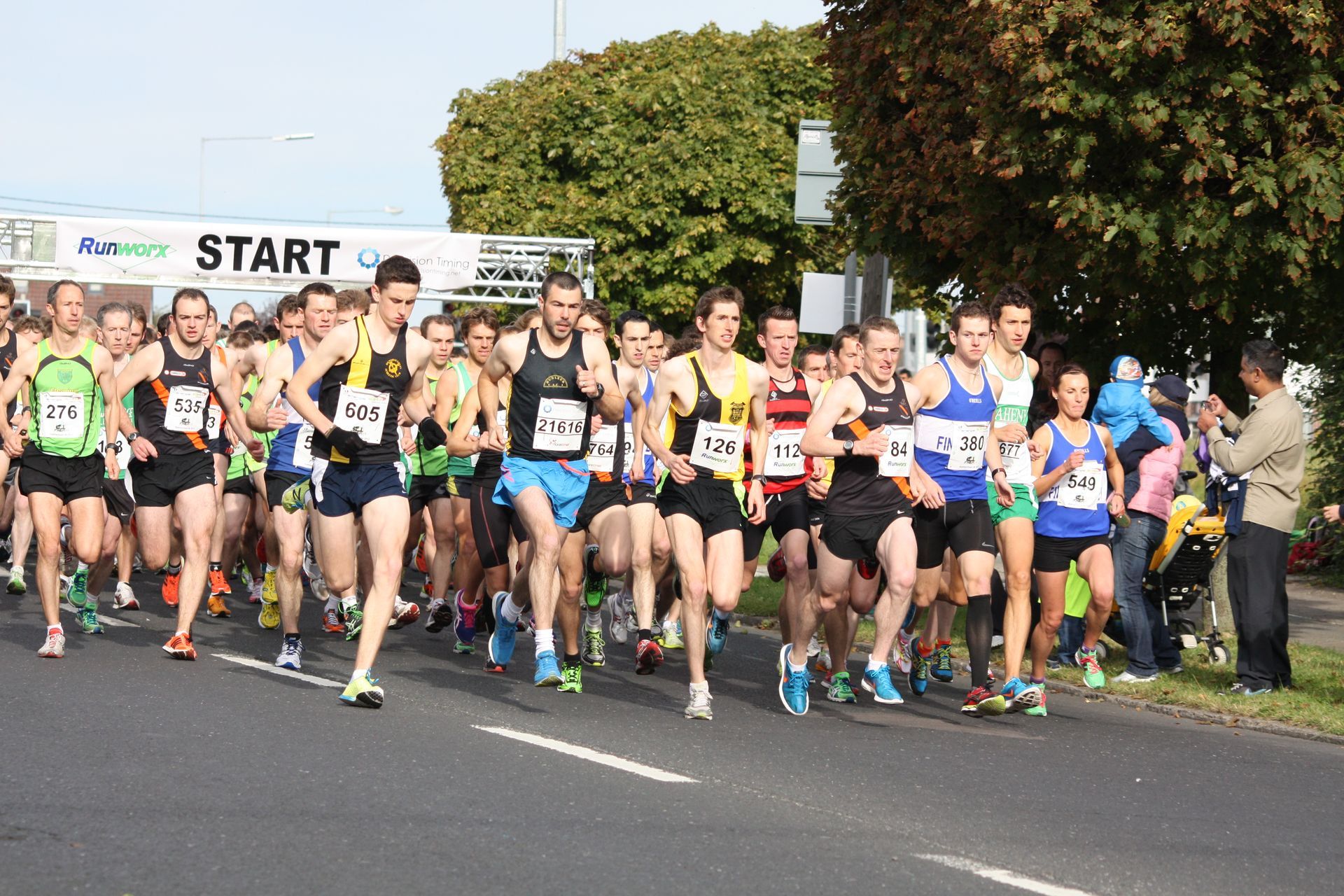 A group of runners are starting a race with a sign that says start