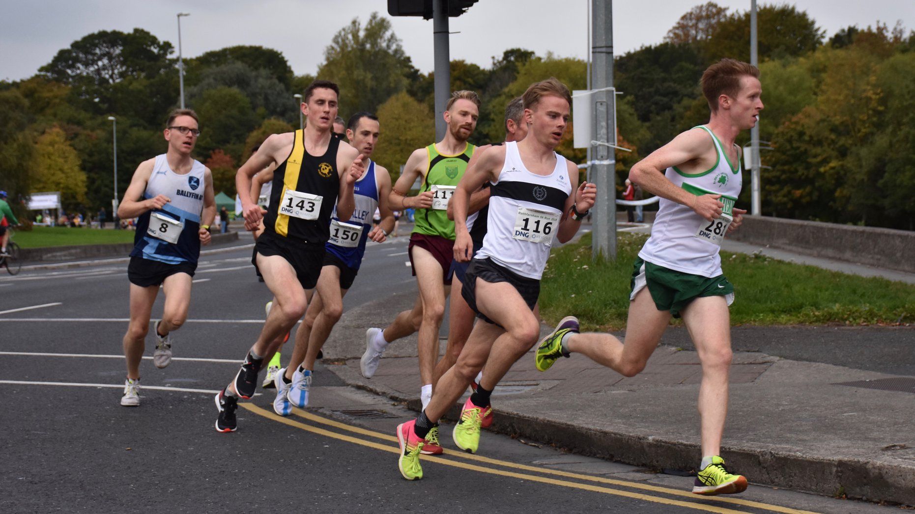 A group of men are running down a street.