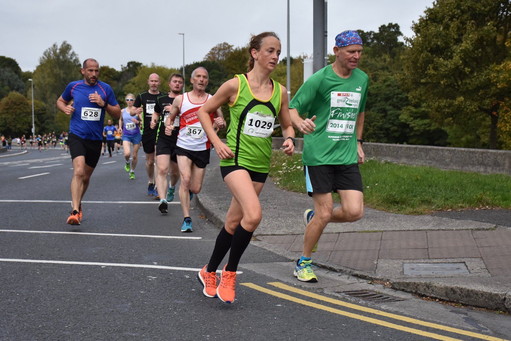A group of people are running a marathon on a street.