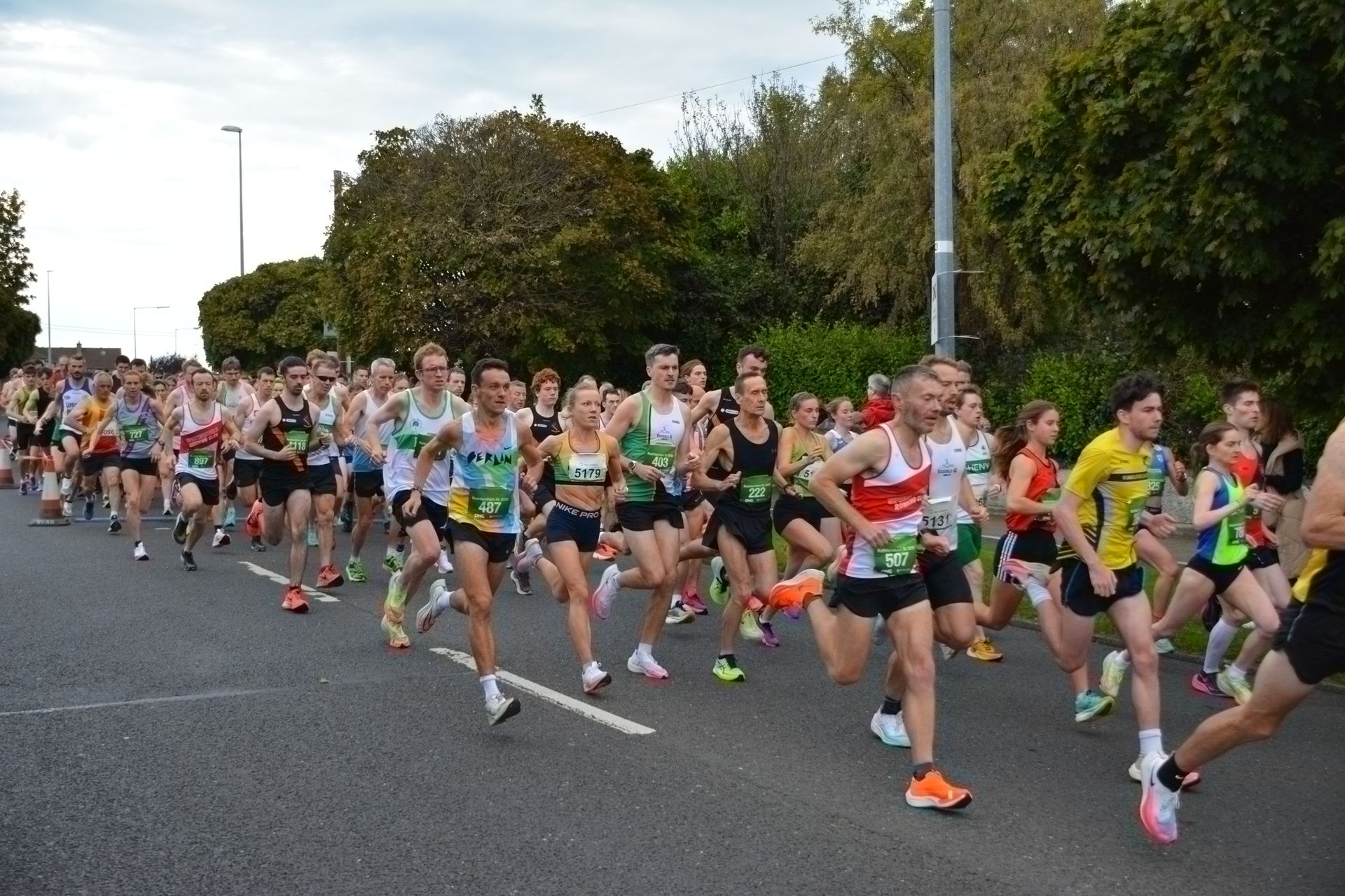 A large group of people are running down a street.