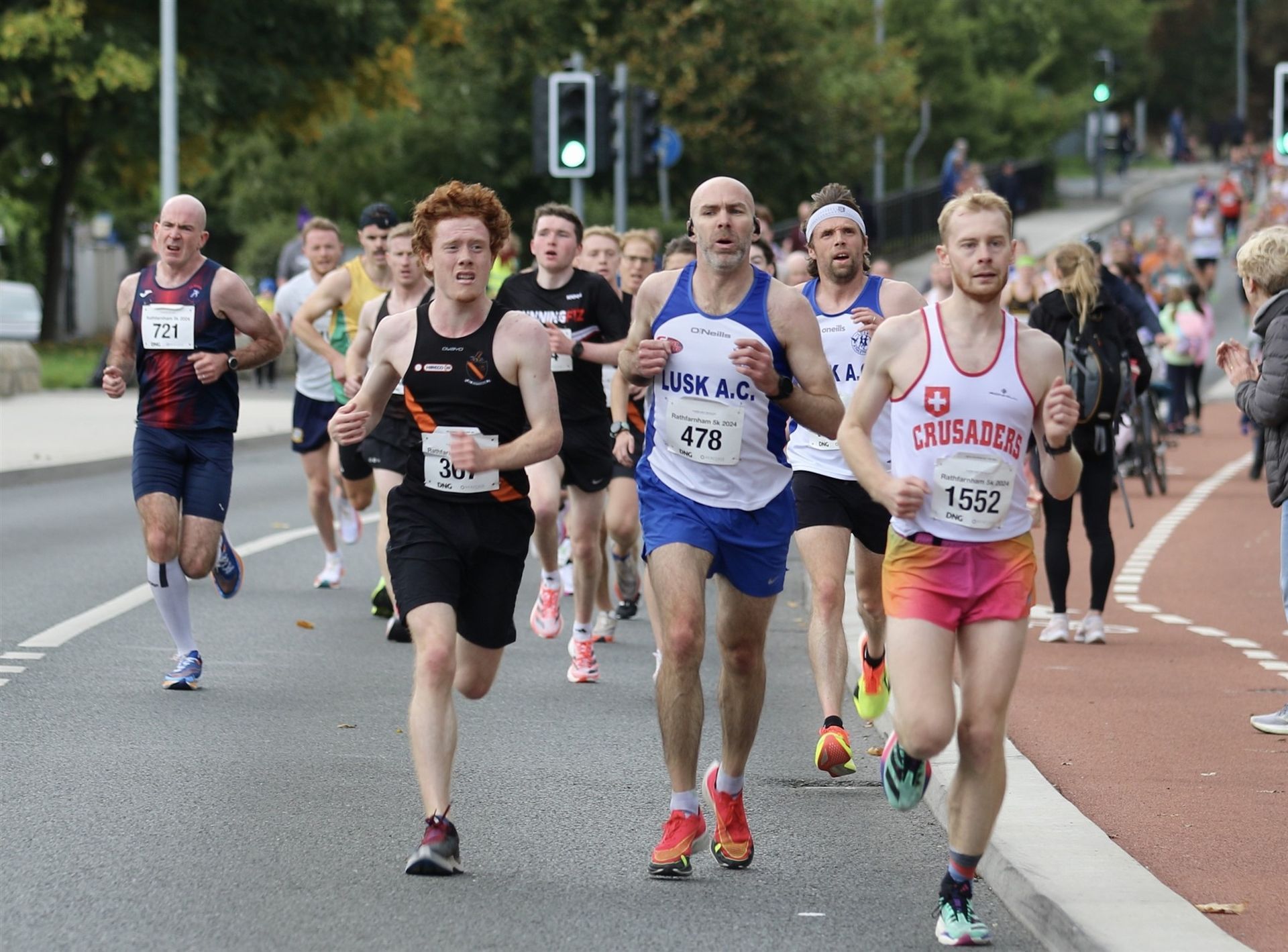 A group of men are running down a street.