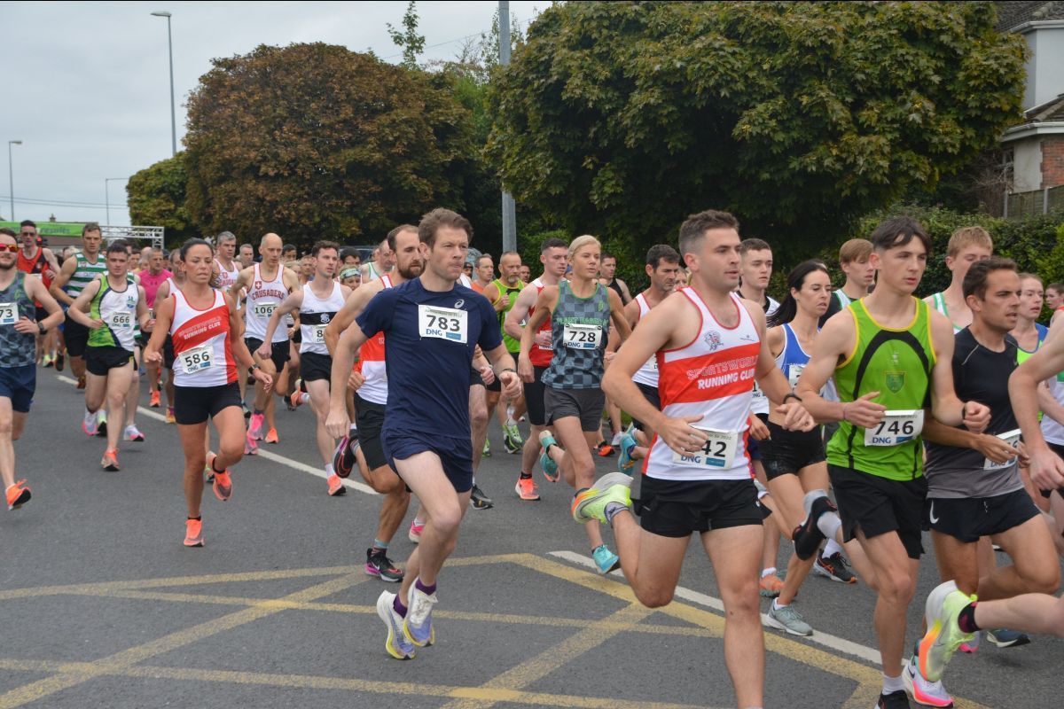 A group of people are running a marathon on a street.