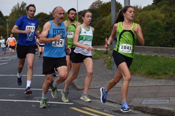 A group of people are running in a race and one of them has the number 1643 on her shirt