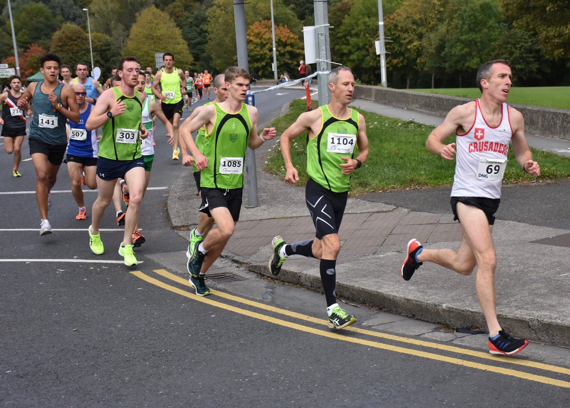 A group of men are running a marathon on a street.