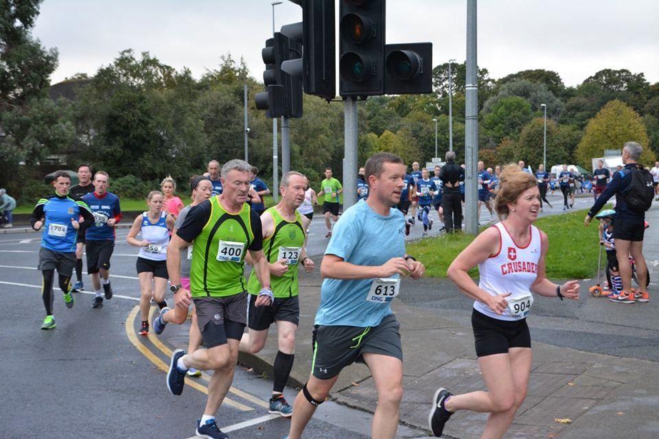 A group of people are running a marathon on a street.