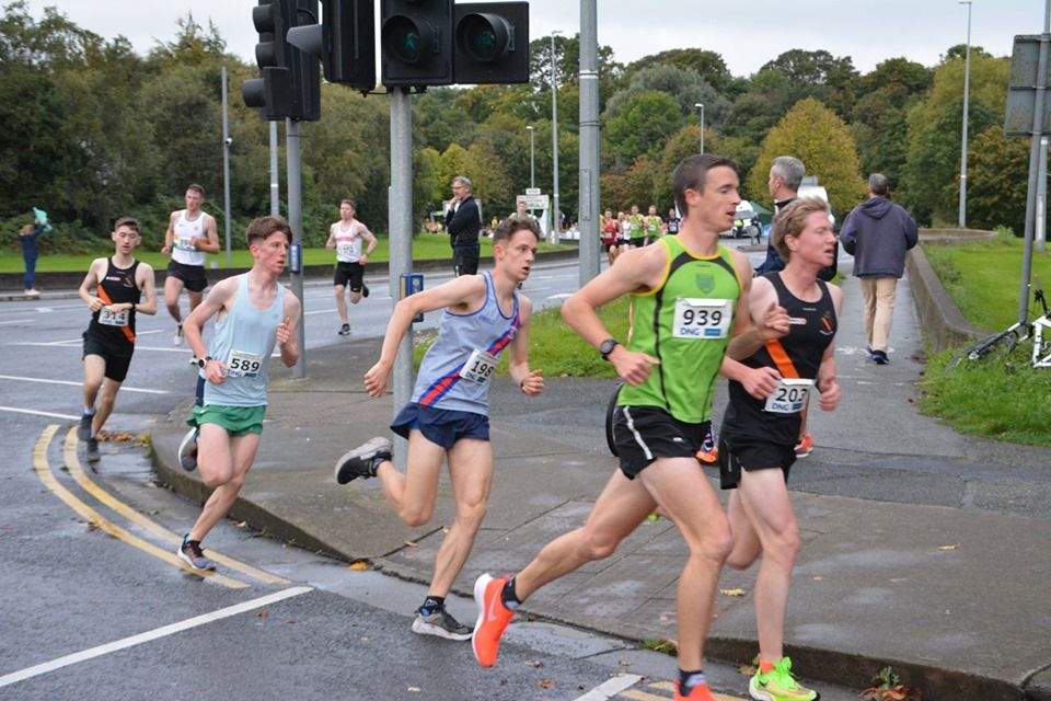 A group of runners are running down a street.