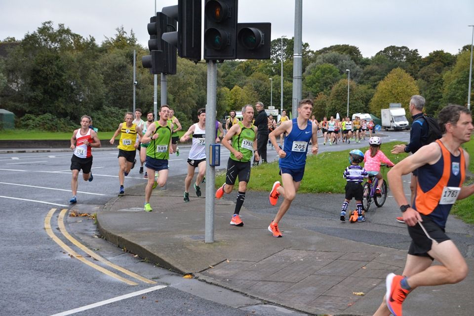 A group of people are running down a street.