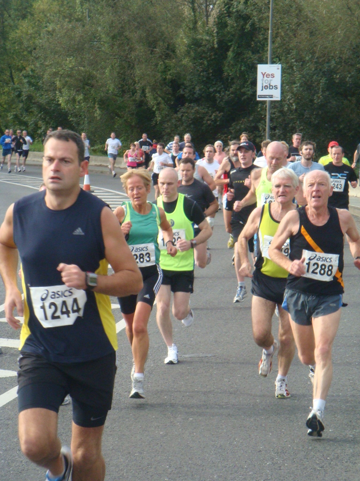 A group of people are running a marathon and one of them has the number 1244 on his shirt