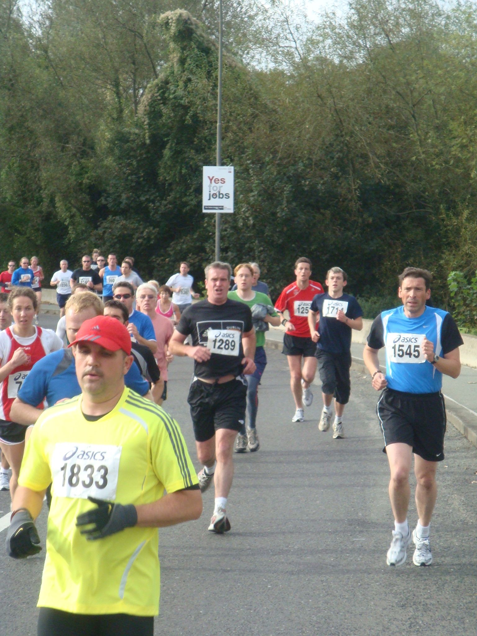 A man in a yellow shirt has the number 1833 on his shirt