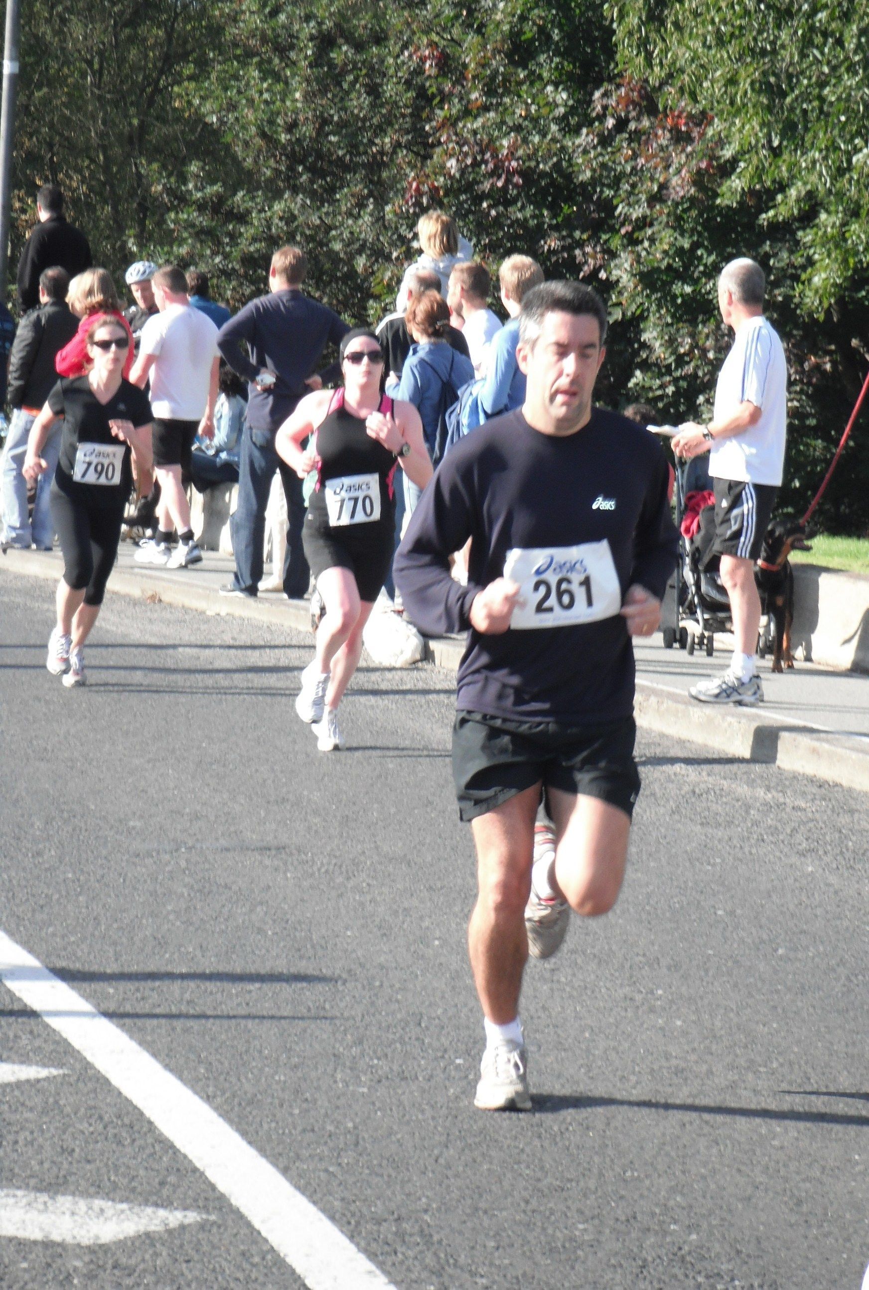 A man with the number 261 on his shirt is running in a race