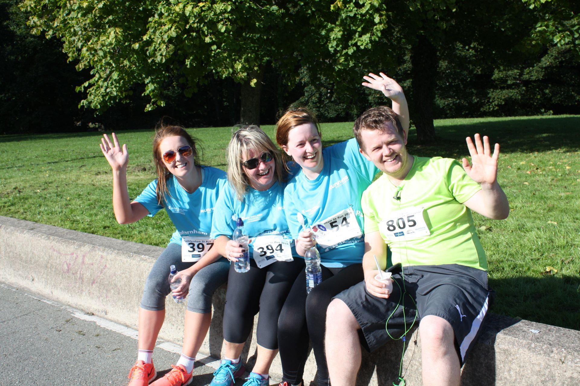 A group of people are posing for a picture while sitting on a curb.