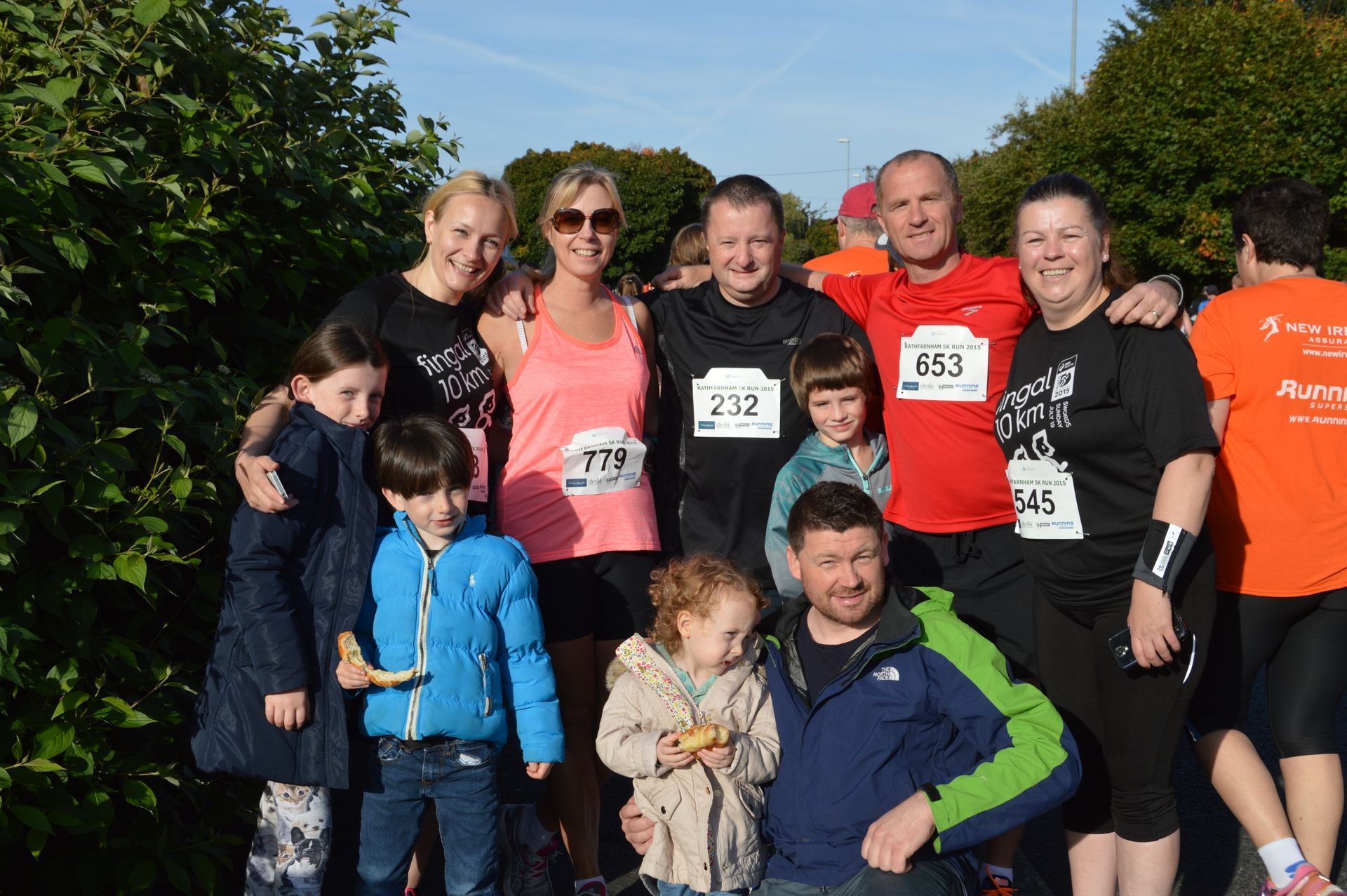A group of people posing for a picture with numbers on their shirts