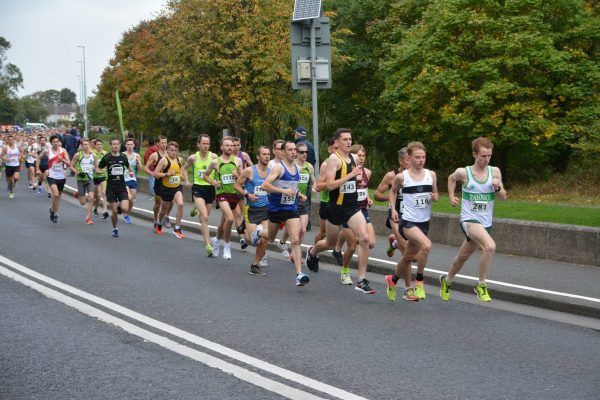 A group of people are running down a road.