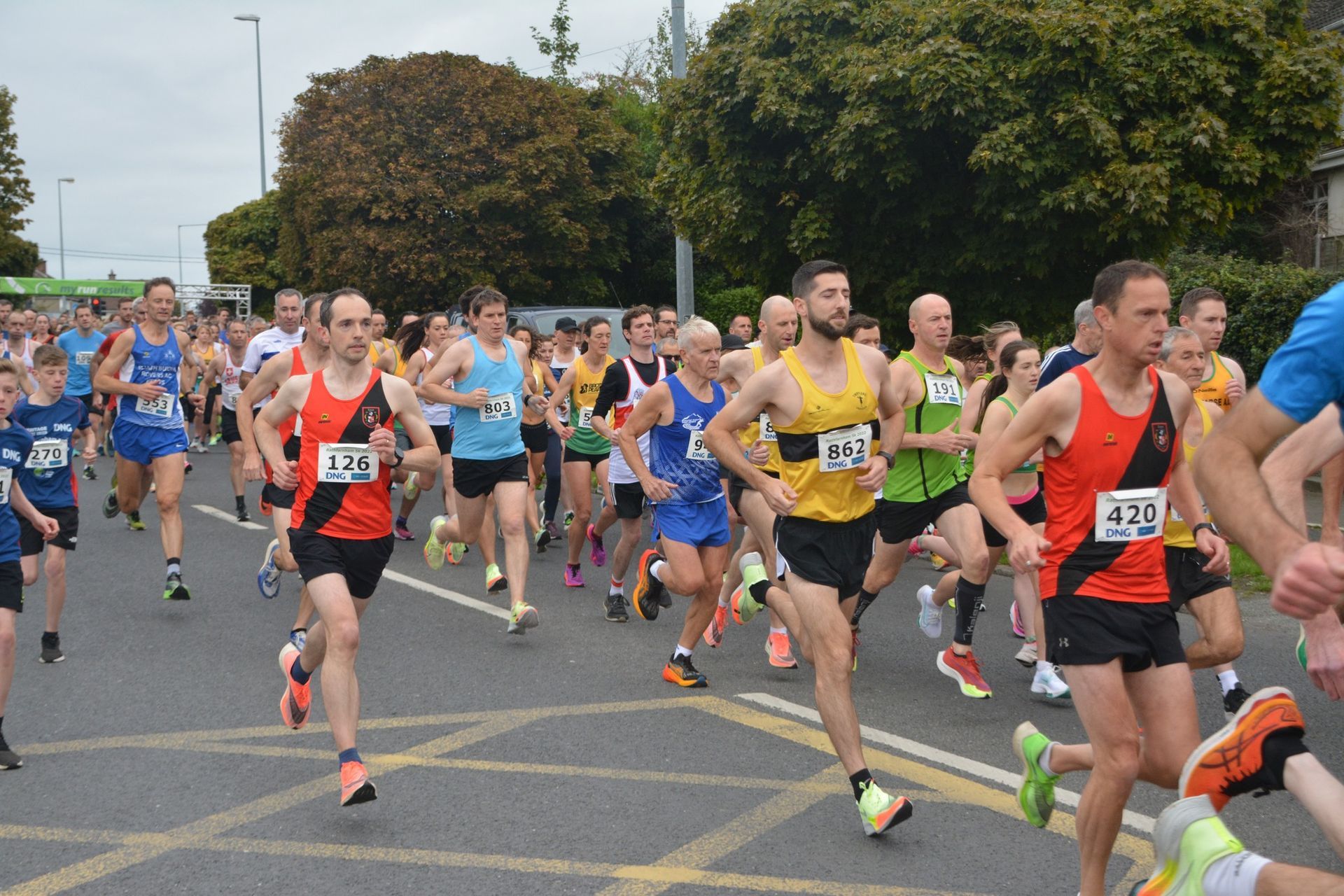 A group of people are running in a race and one of them has the number 476 on his shirt