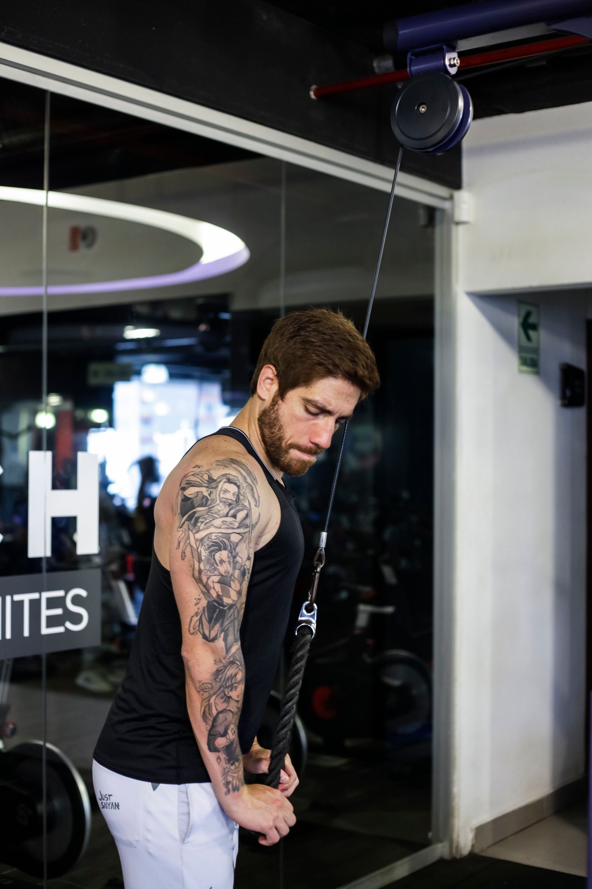 Un hombre está haciendo un ejercicio de tríceps en un gimnasio.