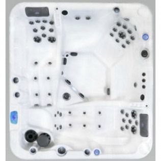 Overhead view of a white, multi-person hot tub with numerous jet nozzles and control buttons.