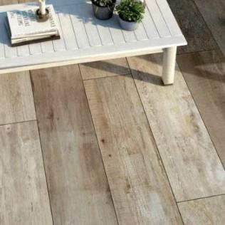 Wooden plank flooring with a white table holding plants and a book.