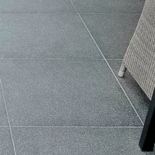 Gray tiled patio with part of a woven chair.