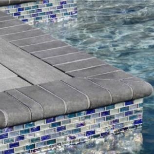 Pool edge with gray coping and blue tile, water visible.