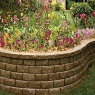 Low, curving brown brick retaining wall with a colorful flower bed.