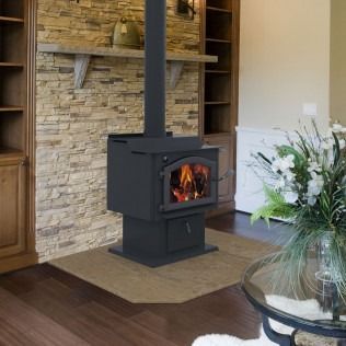 Black wood-burning stove with flames in a living room, set on a tan hearth pad.